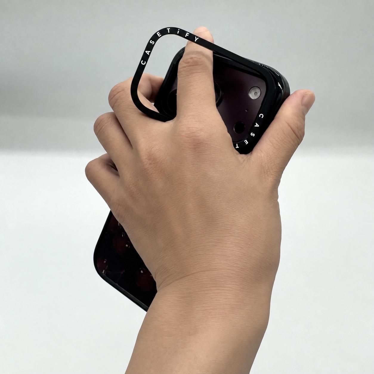 CASETiFYのカメラリングに指を通してiPhoneをホールドしている様子